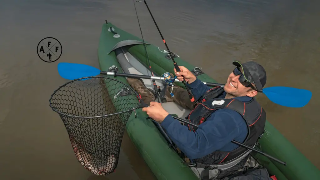 Man on inflatable fishing kayak with fish in net